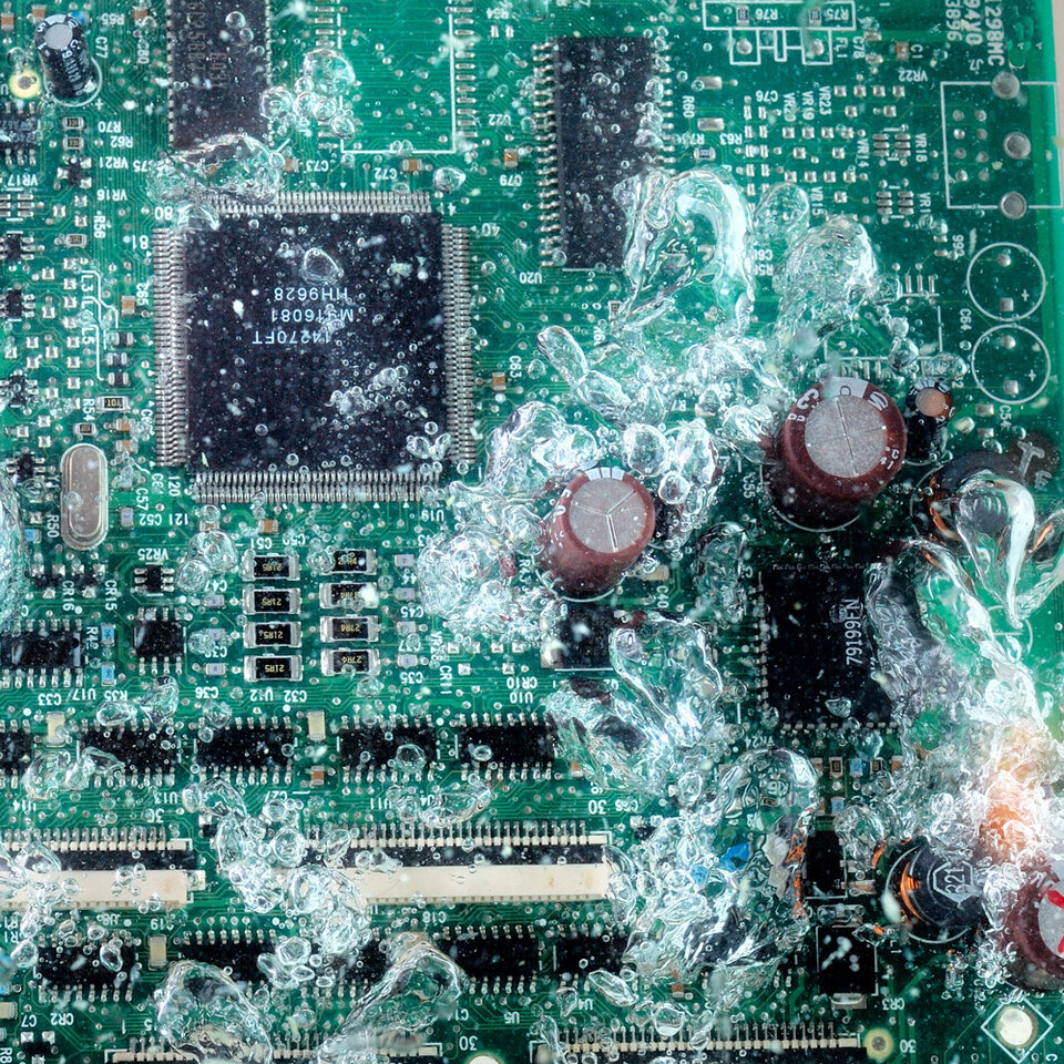 Eine Baugruppe wird von Spülwasser umgeben und gereinigt. 