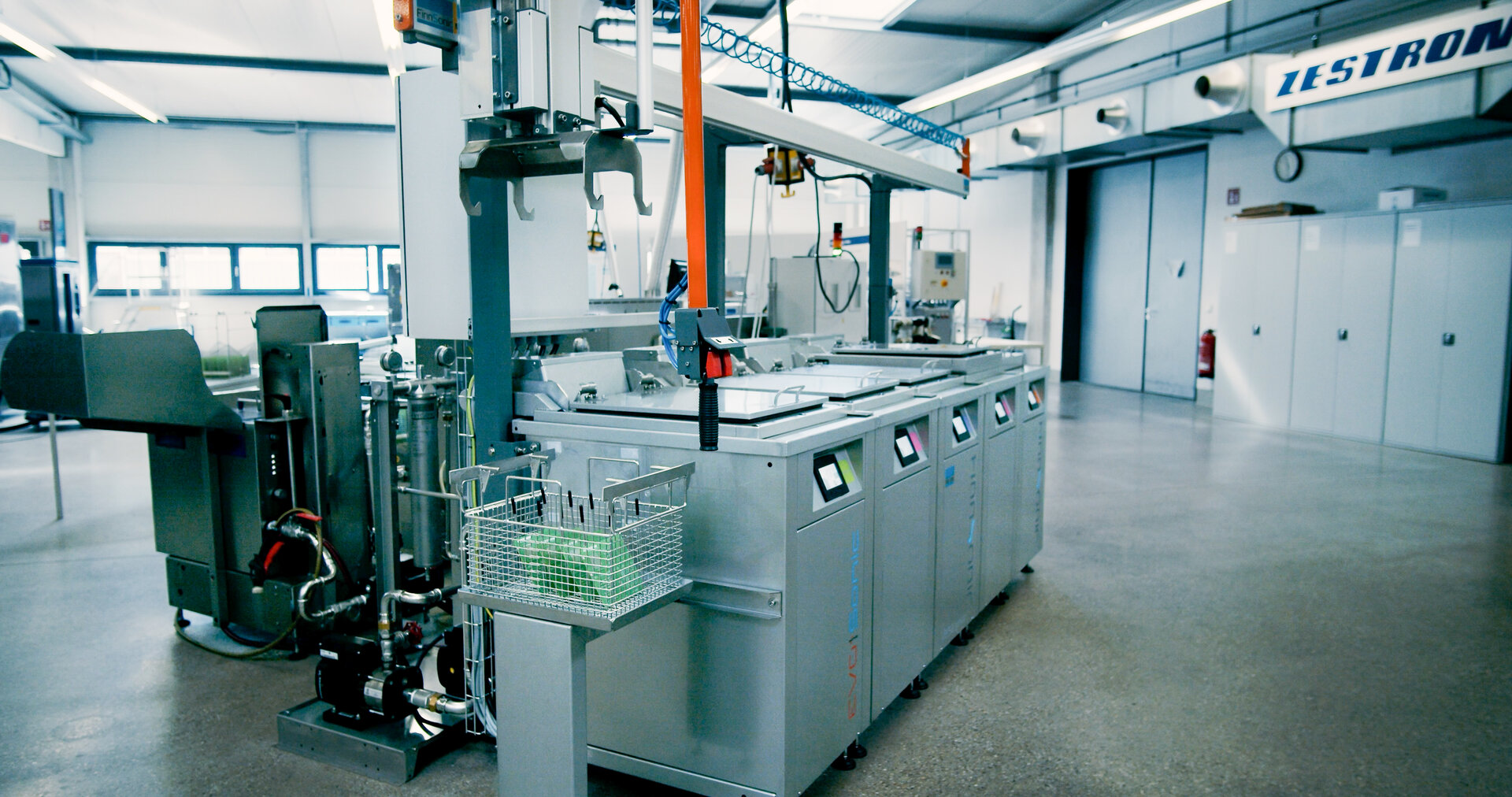 Zu sehen ist eine Semi-Inline-Reinigungsanlage, die durch Ultraschall elektronische Baugruppen reinigt.