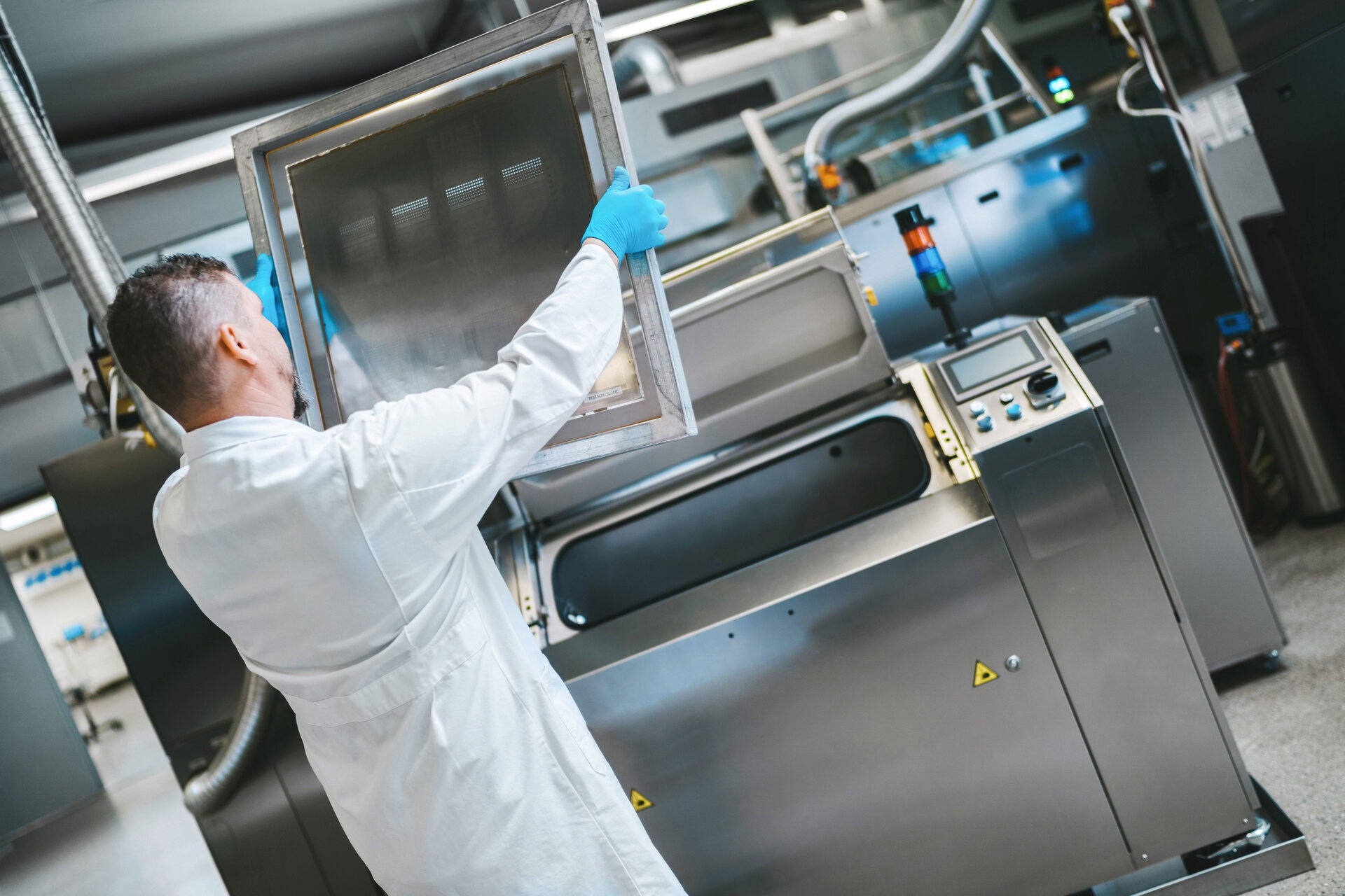 La limpieza del esténcil es importante para la producción electrónica. Por ello, el empleado comprueba el esténcil después del proceso de limpieza.  | © @The Sour Cherry Fotografie - Michaela Curtis