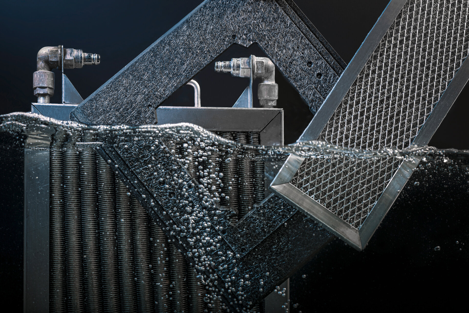 Jedna rama lutownicza i dwie pułapki kondensatu w połowie zawieszone w wodzie | © Zestron