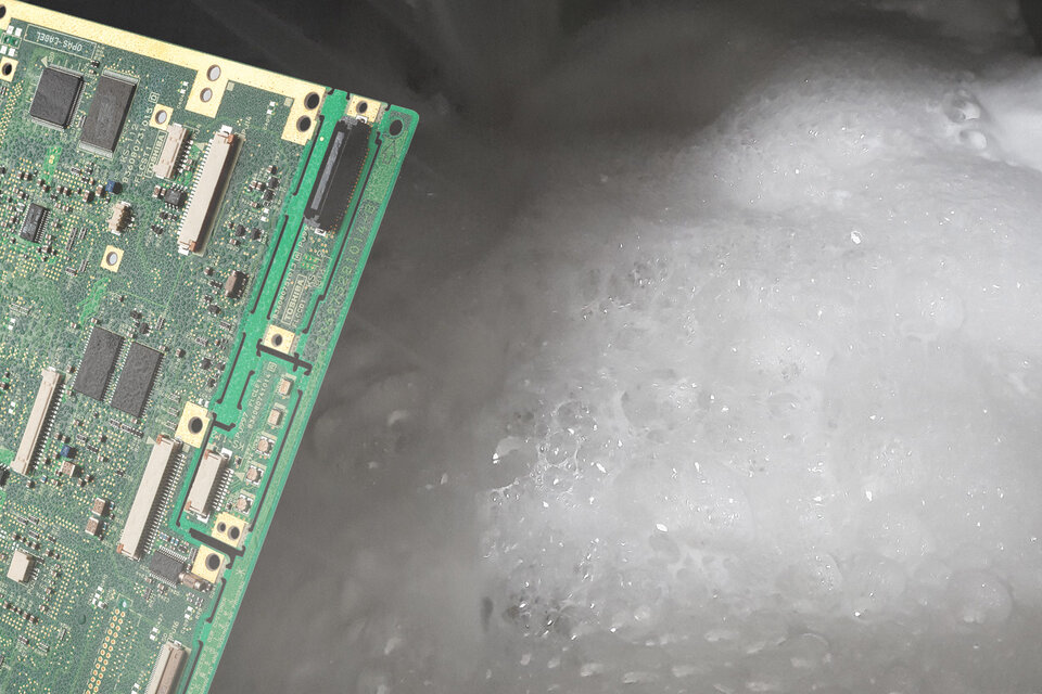 Es wird eine grüne Leiterplatte auf der linken Seite gezeigt und auf der rechten Seite ist Schaum zu sehen, der für die Schaumbildung beim Reinigungsprozess steht.