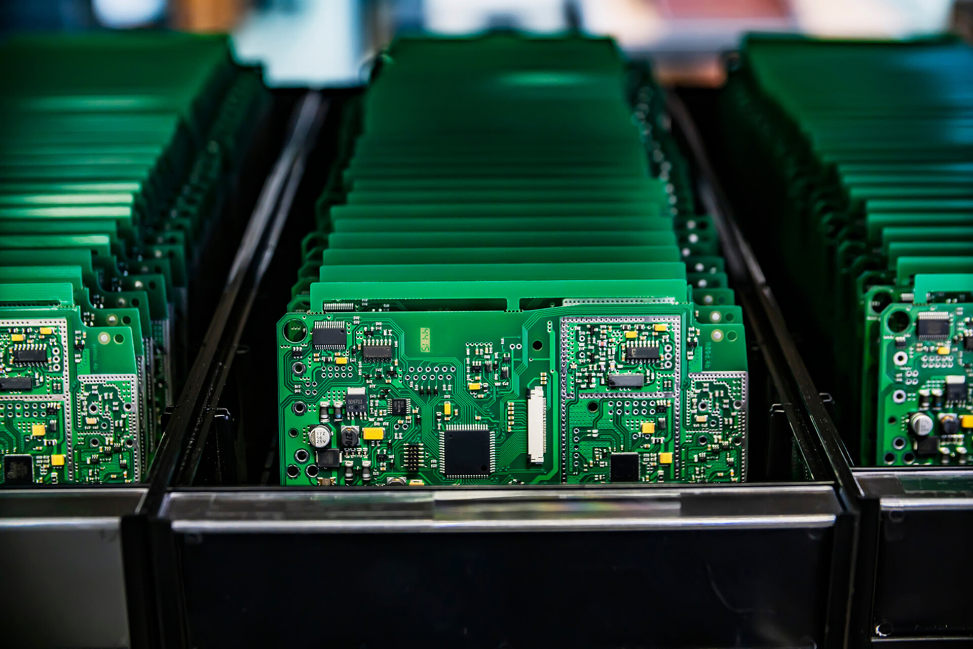 The image shows assembled green PCBs being processed in a clean production environment. This illustration emphasises the importance of the combination of a clean room and an integrated cleaning process for the production of electronic assemblies. | © Zestron 