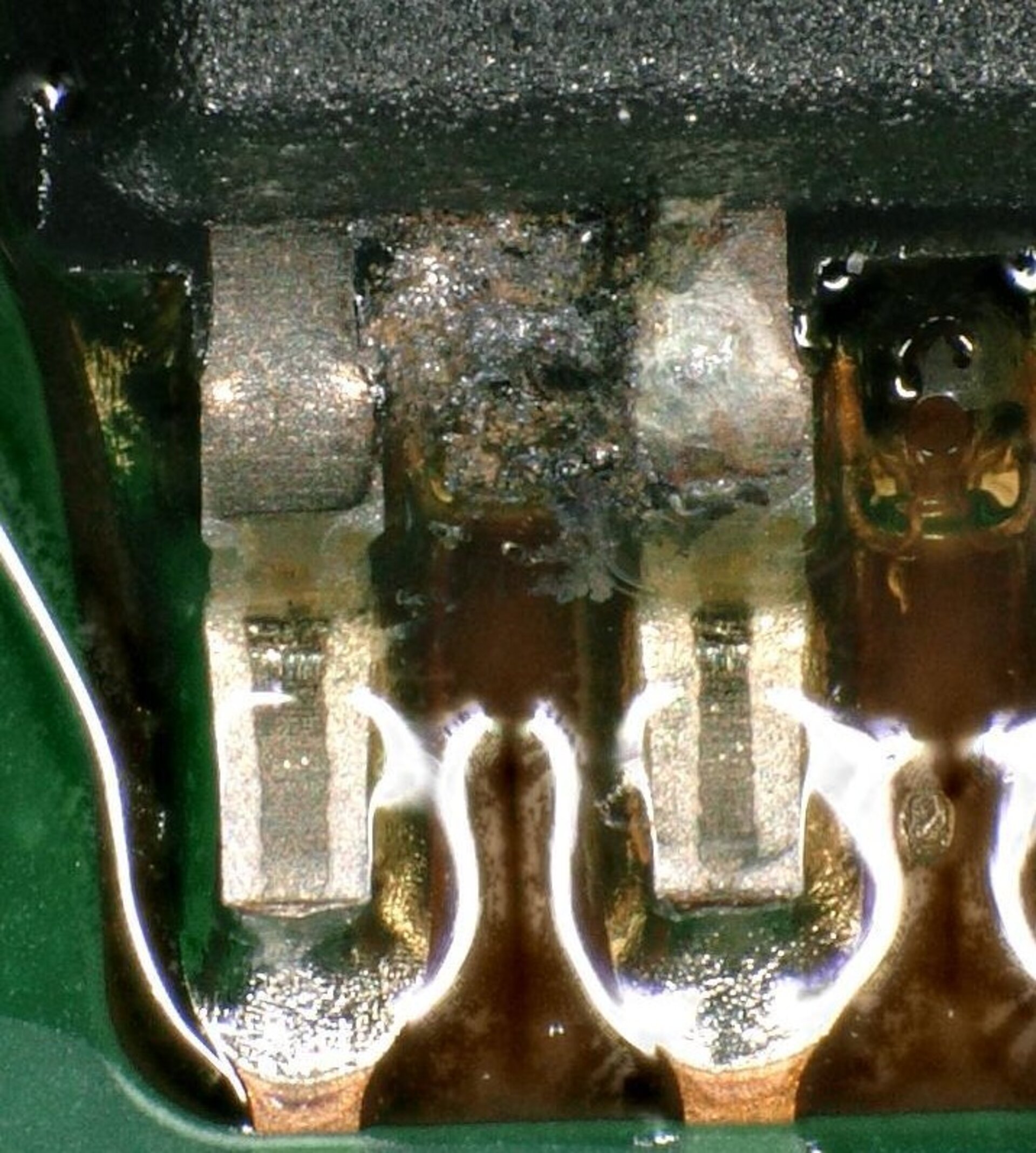 Auf dem Bild ist eine Nahaufnahme einer Leiterplatte zu sehen, die das Fehlerbild Kriechstrom zeigt.  | © Zestron