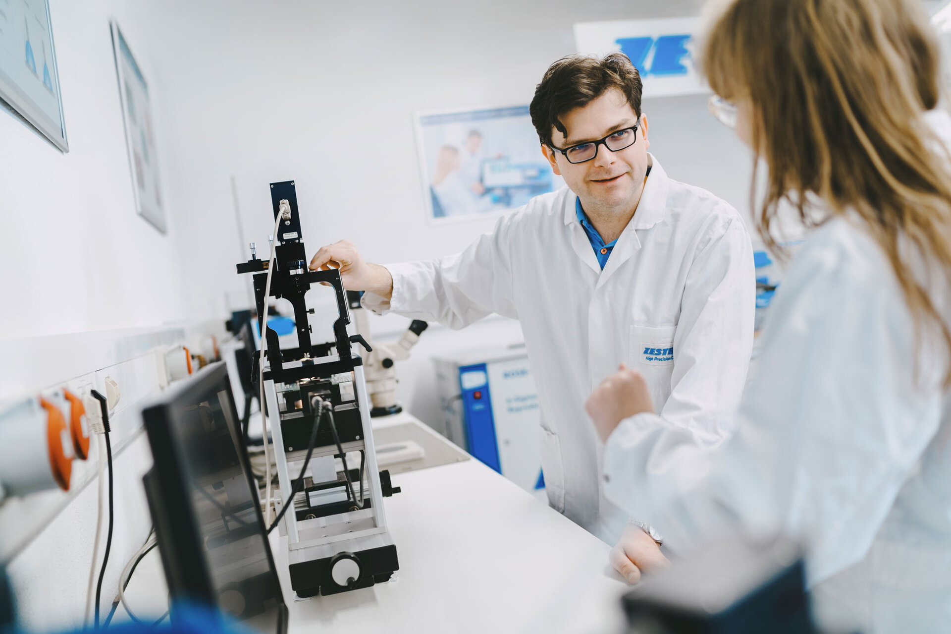 Dwóch pracowników laboratorium znajduje się w centrum analitycznym i przeprowadza procedurę analizy chromatografii jonowej. | © @The Sour Cherry Fotografie - Michaela Curtis