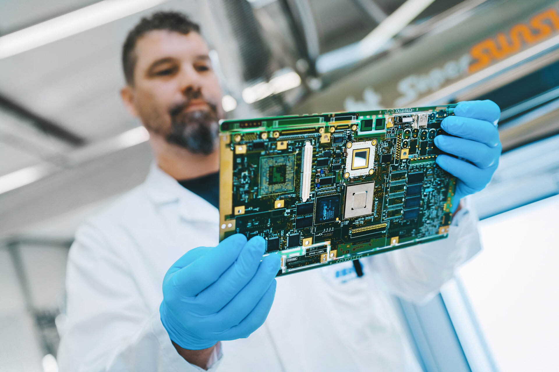 Une fois le nettoyage du circuit imprimé réussi, l'ingénieur le tient dans sa main pour vérifier l'absence de résidus. | © @The Sour Cherry Fotografie - Michaela Curtis