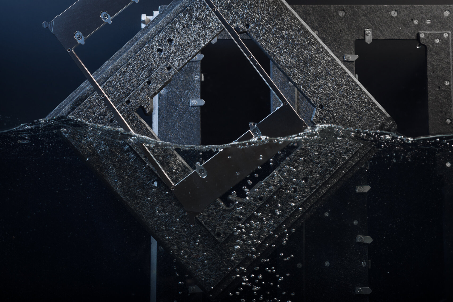 Drei Lötpaletten zur Hälfte in Wasser getaucht als Sinnbild für die Lötrahmen- und Warenträgerreinigung.  | © Zestron