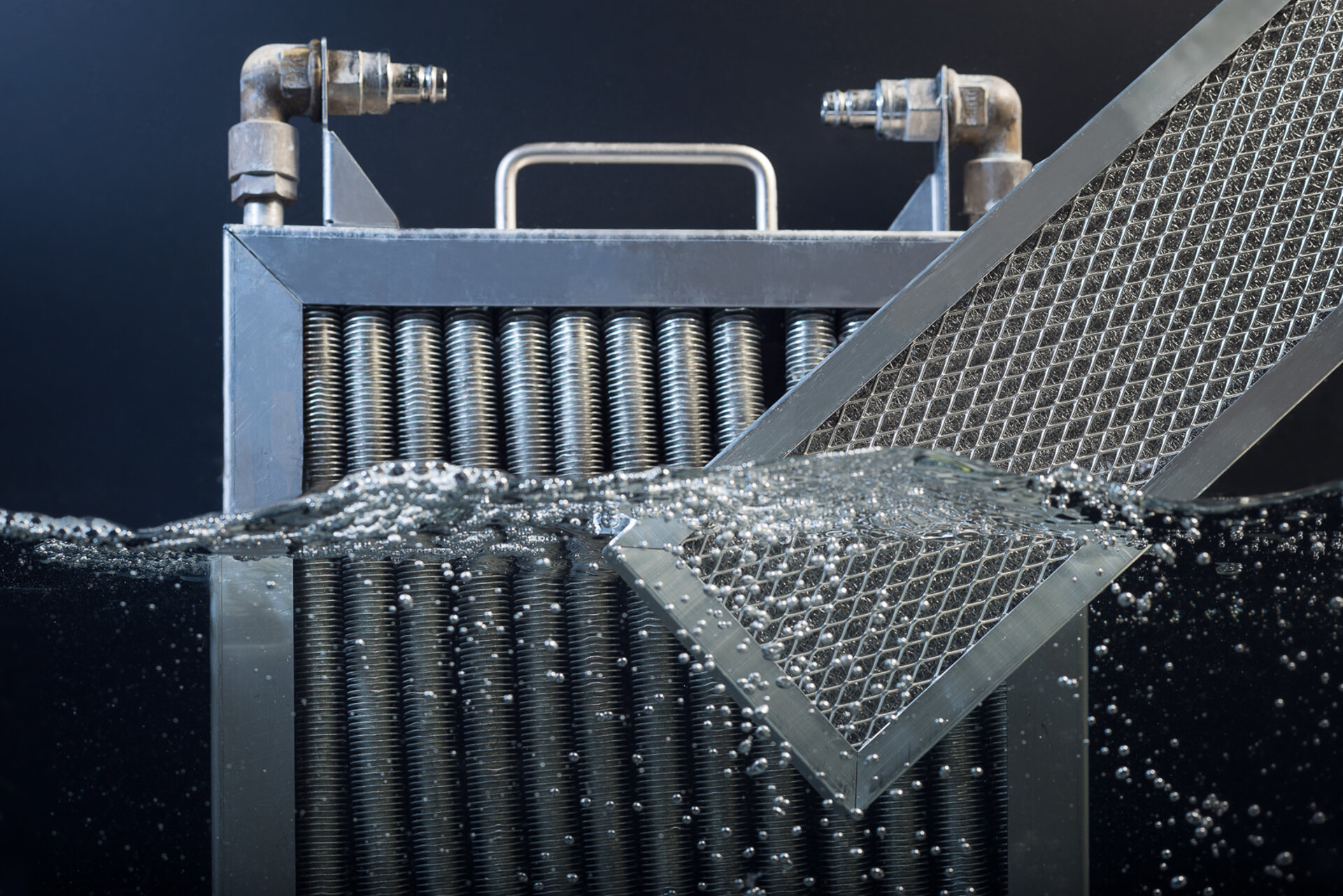 Kondensatfalle und Filter zur Hälfte in Wasser getaucht als Sinnbild für die Vorteile einer regelmäßigen Reinigung.  | © Zestron