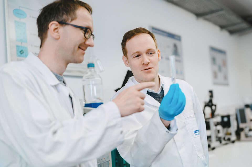 Two employees are conducting a surface cleanliness analysis of electronic assemblies in the laboratory. | © @The Sour Cherry Fotografie - Michaela Curtis