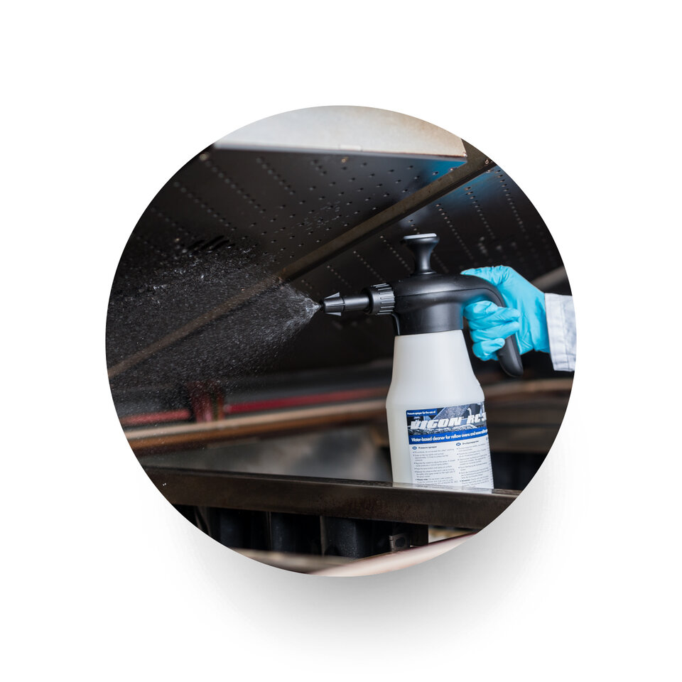 engineer spraying a reflow oven using zestron cleaning chemistry 