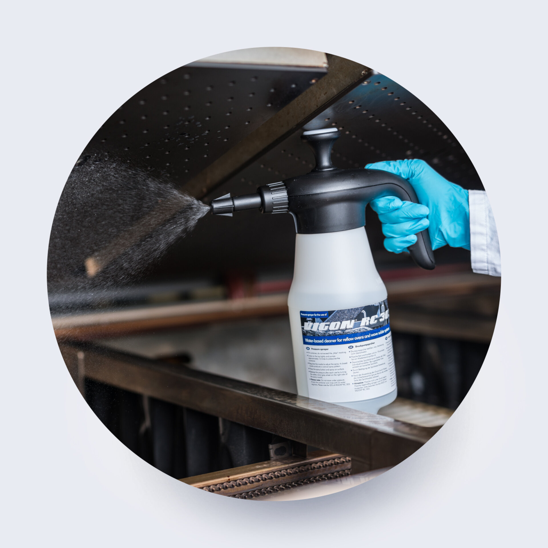 engineer spraying a reflow oven using zestron cleaning chemistry 