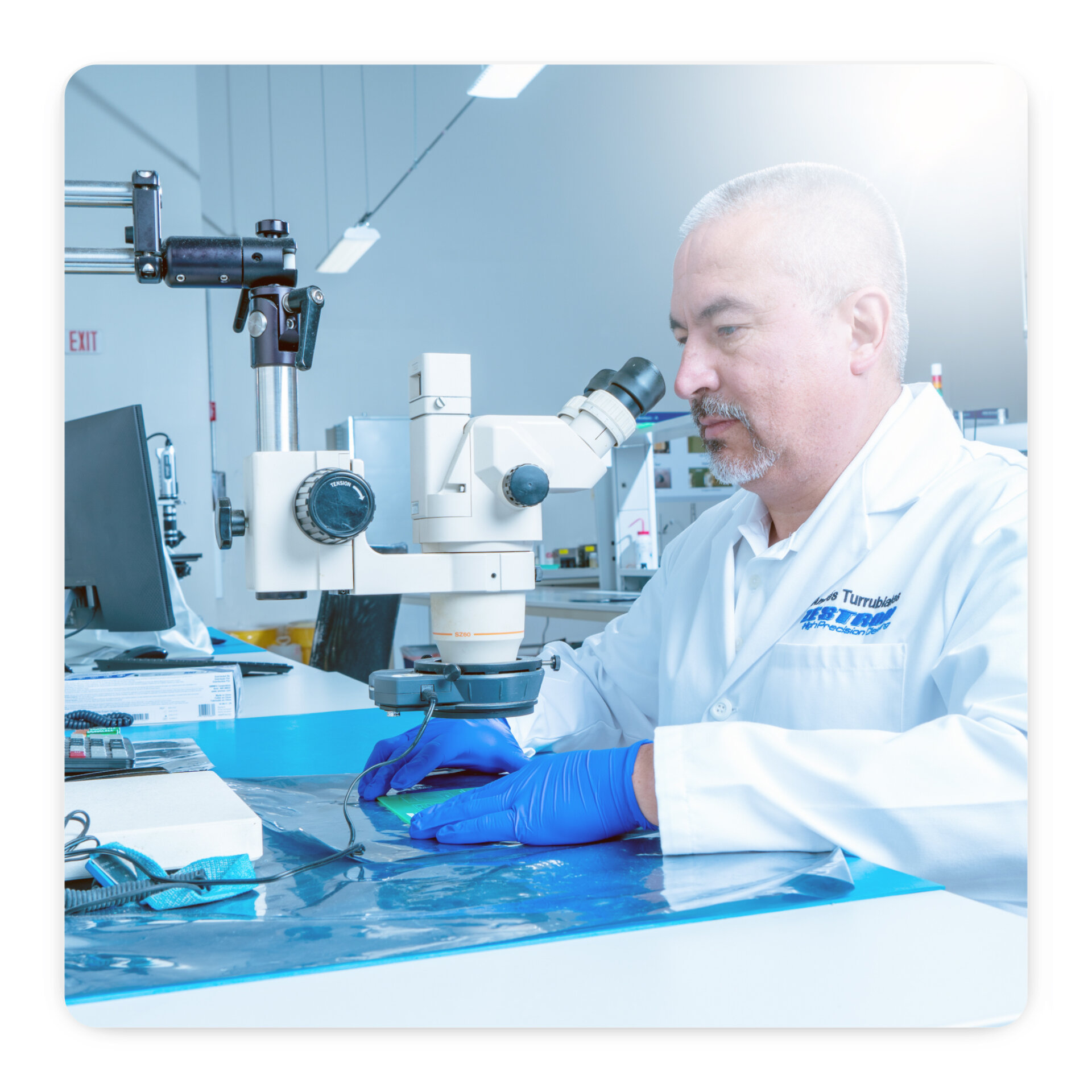 zestron engineer looking into microscope to inspect pcb 